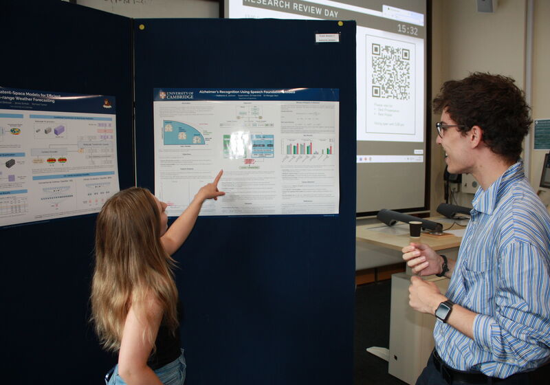 Students discussing a poster at the MLMI Research Review Day.
